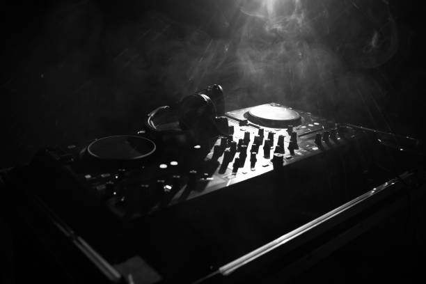 istock DJ Spinning, Mixing, and Scratching in a Night Club, Hands of dj tweak various track controls on dj's deck, strobe lights and fog, or Dj mixes the track in the nightclub at party 968640068