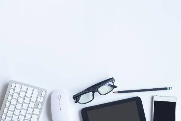 Photo of White desk office with laptop, smartphone and other supplies with cup of coffee. Top view with copy space for input the text. Designer workspace on desk top, view with essential elements on flat lay.