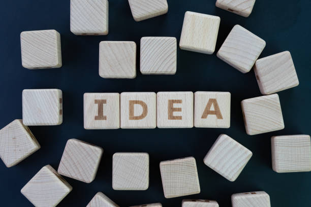 istock Great creative idea concept, cube wooden blocks with alphabet building the word IDEA on dark black chalkboard 968670824