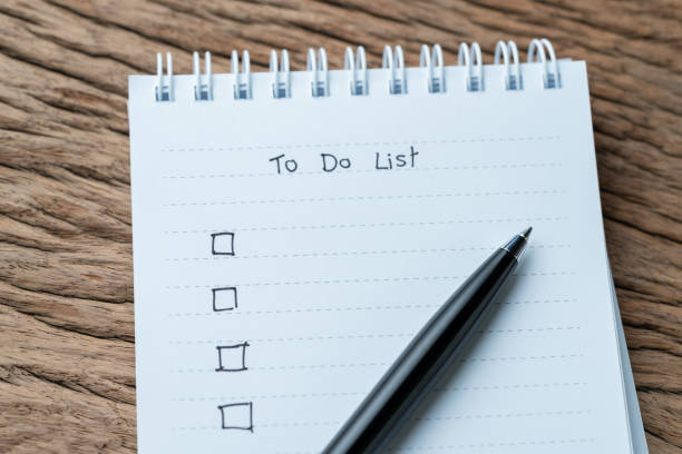 istock Task checkmark, To Do List checkbox written with pen on white paper notepad on wood table in soft tone, writing business project with tasks priority concept 968670942