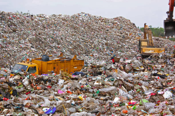istock Garbage truck and backhoe working on municipal garbage dump 968685560
