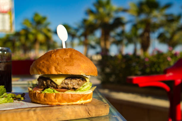 istock Burger with a cutlet on a wooden board in a cafe, restaurant 968704066