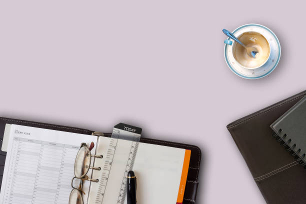 istock Notebook pen and coffee cup on light purple desk 968706696
