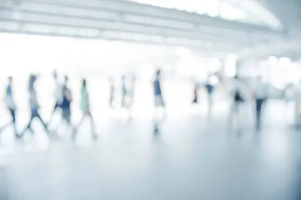 Photo of white blurred of people walking in city town. Defocused blur background.