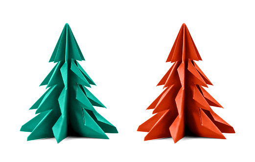 Origami Christmas tree paper isolated on white background. For decoration, Merry Christmas or Happy New Year postcard. Green and red color. Front view. Close up.
