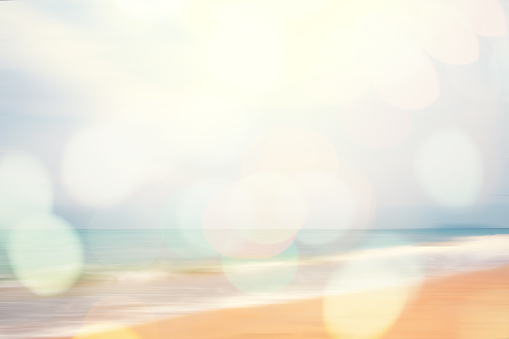 A seascape abstract beach background. panning motion blur and bokeh light of lens flare, pastel colors in a vintage and retro style.