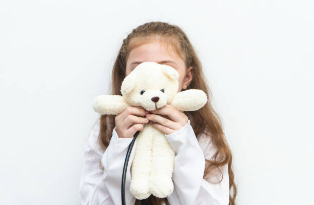 istock Little kid playing nurse doctor with teddy bear 968768626