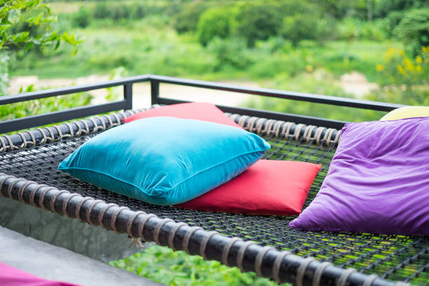 istock Multi-colored pillows placed on the net. The background is a river and green forest. 968774794