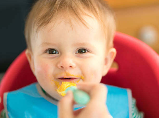 istock Baby sitting in highchair eating 968775210