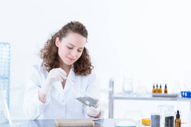 Laborer woman taking a sample Laborer woman taking a sample of the material to be tested in the laboratory colloid stock pictures, royalty-free photos & images