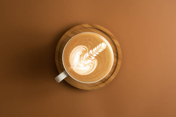istock Coffee cup with wooden plate on brown color background. 968788728