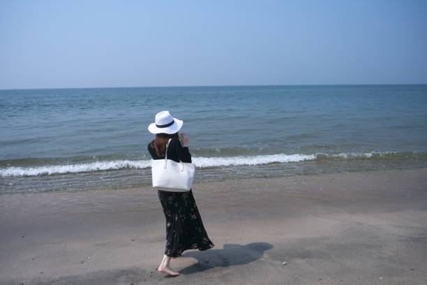 istock Girl walking on wet sandy beach 968789578