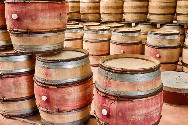 Empty barrels of wine are stacked up in a winery cellar waiting to be used after the next harvest.