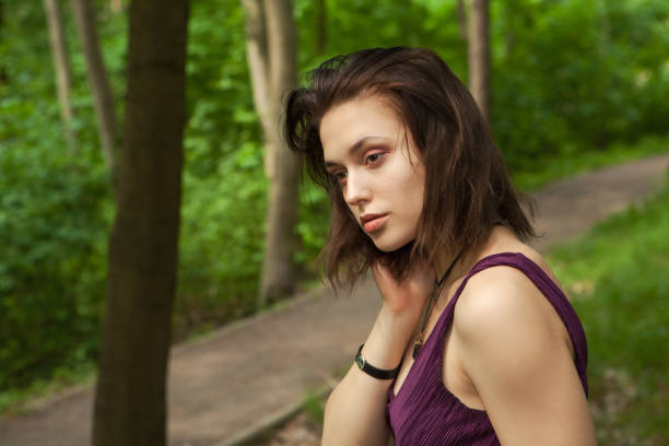 primer plano retrato de una hermosa joven de 18 años en un vestido morado en un bosque de verano - one person one young woman only 18 19 years teenage girls fotografías e imágenes de stock