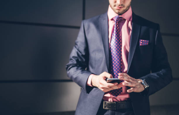 istock Young elegance man standing outdoor and using mobile phone. 968796768