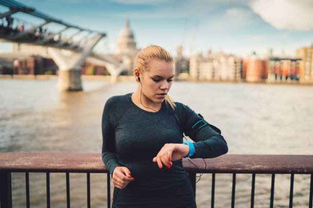 istock Sportswoman in UK checking pulse on smart watch during workout 968802324