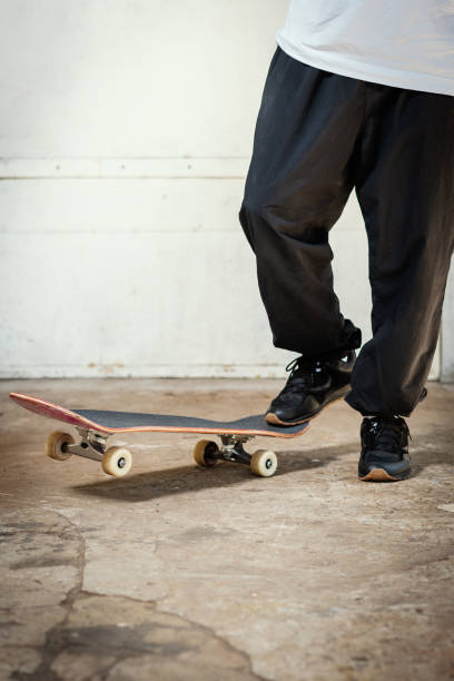 istock man in black pants stands with one foot on a skateboard 968819446