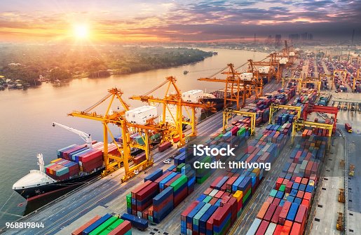 istock Logistics and transportation of Container Cargo ship and Cargo plane with working crane bridge in shipyard at sunrise, logistic import export and transport industry background 968819844