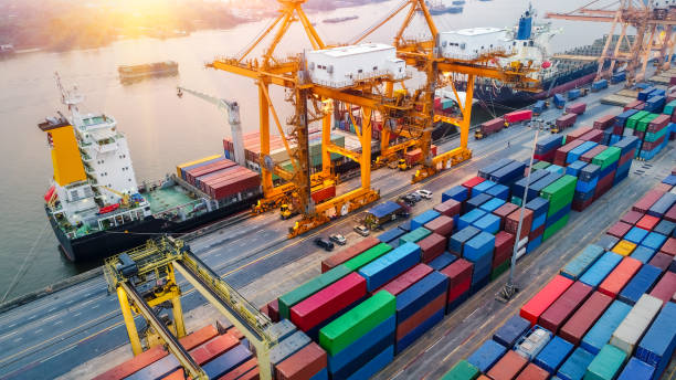 istock Logistics and transportation of Container Cargo ship and Cargo plane with working crane bridge in shipyard at sunrise, logistic import export and transport industry background 968819952