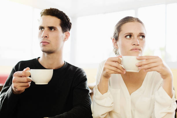 Man taking tea. Bearded man smiling while taking cup of tea from psychologist