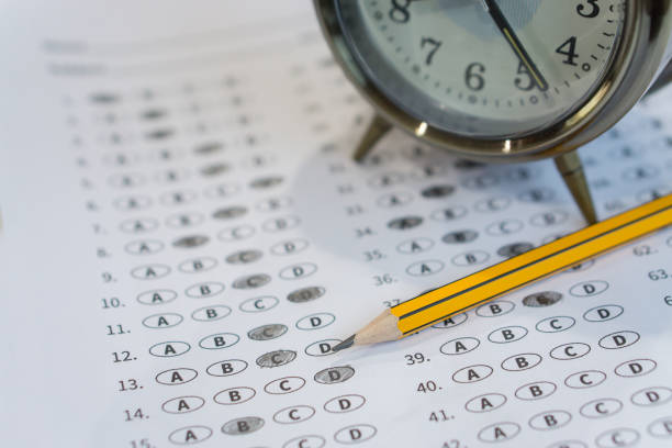 alarm clock, optical form of standardized test with bubbled and a black pencil examination,Answer sheet,education concept,selective focus,vintage color stock photo