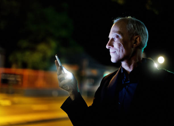 istock Man using his smart phone in the street at night 968830756