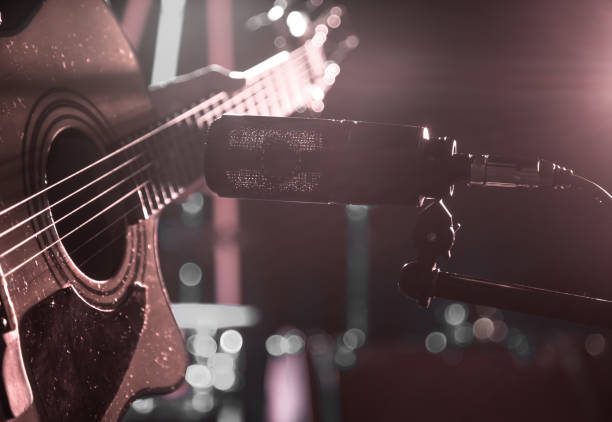 istock The Studio microphone records an acoustic guitar close-up. Beautiful blurred background of colored lanterns. 968838150