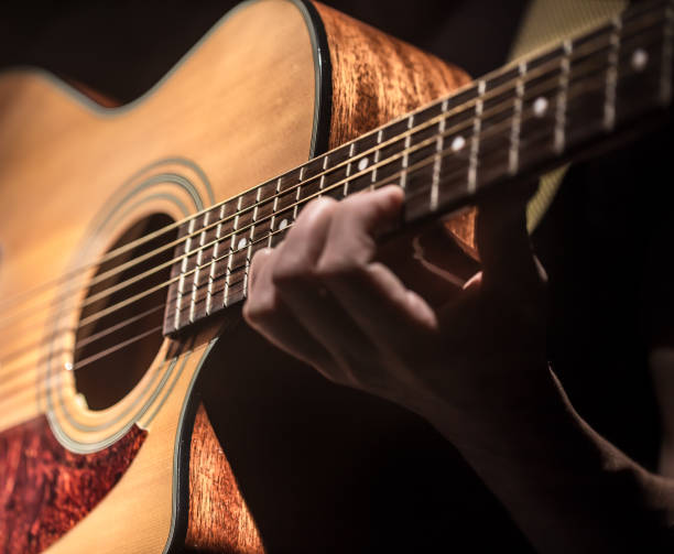 istock Man playing acoustic guitar on dark background. A musical concept. 968838186
