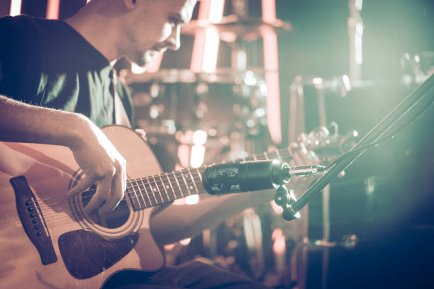 istock The Studio microphone records an acoustic guitar close-up. Beautiful blurred background of colored lanterns. 968838192