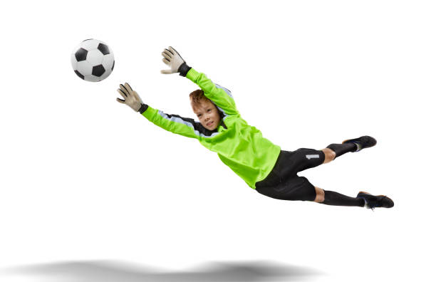 goalkeeper kid flying for the ball isolated on white goalkeeper kid jumping for the ball isolated on white teen goalie stock pictures, royalty-free photos & images