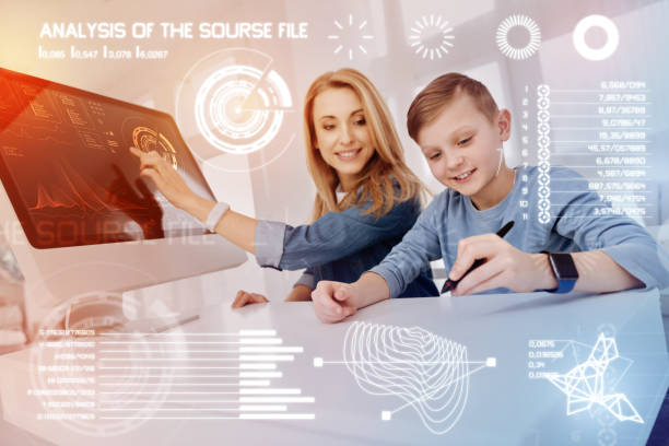 istock Diligent pupil holding a stylus while his teacher smiling 968838630