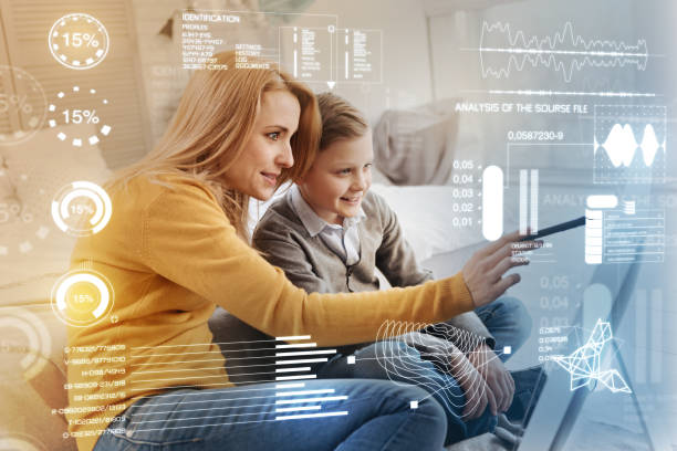 istock Attentive woman holding a stylus while showing a new program to her son 968839112