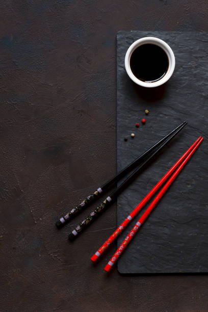 istock Chopsticks and bowl with soy sauce on black stone background 968841536