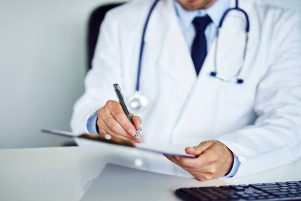 istock Male doctor writes notes on the clipboard in the office 968845334