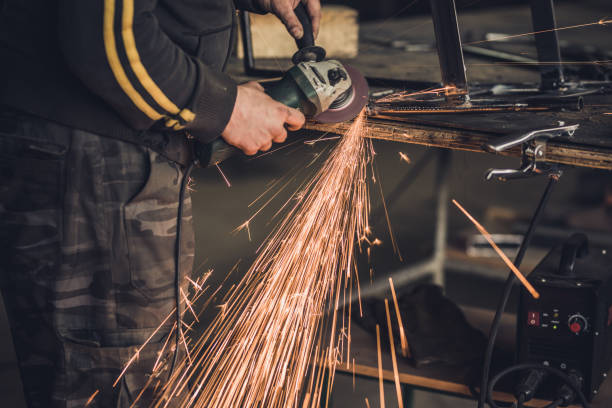 istock Unrecognizable manual worker working in a factory while welding an iron with hand saw. 968845886