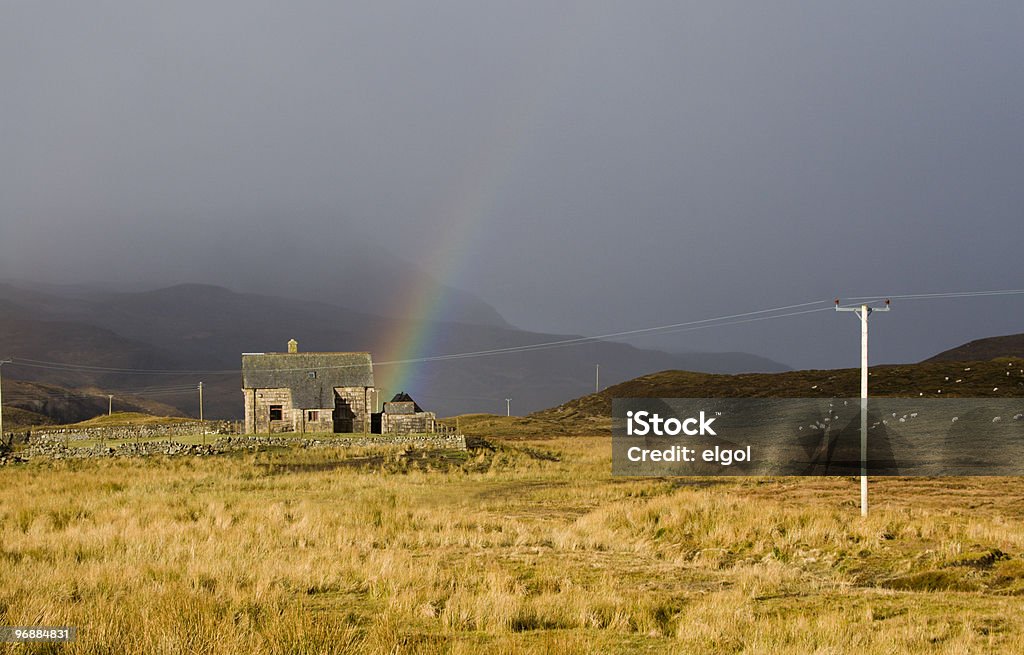 Шотландский Небольшой коттедж с Storm и Rainbow - Стоковые фото Loch Assynt роялти-фри