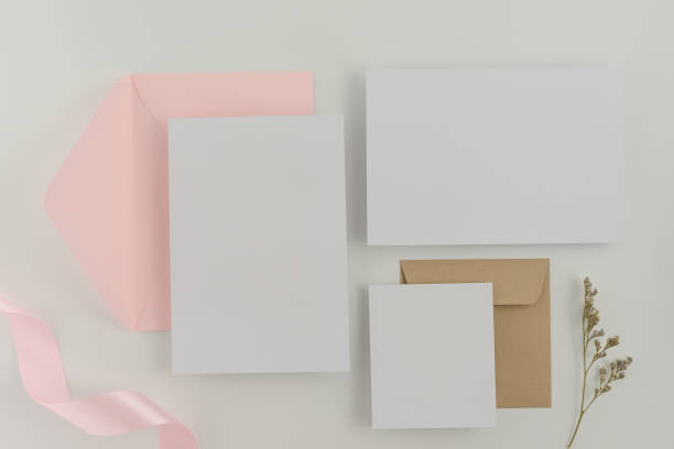 istock A wedding mock up concept. Wedding Invitation, envelopes, cards Papers on white background with ribbon and decoration. Top view, flat lay, copy space 968852592