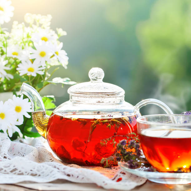 istock Cup with hot tea with mint and a thyme on a wooden table in a summer garden. Selective focus 968853486