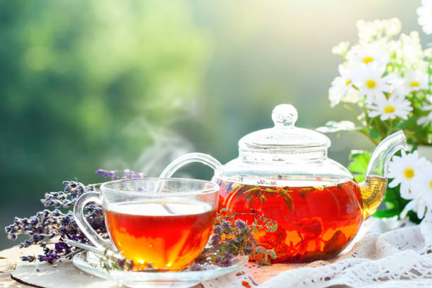 istock Cup with hot tea with mint and a thyme on a wooden table in a summer garden. Selective focus 968855552