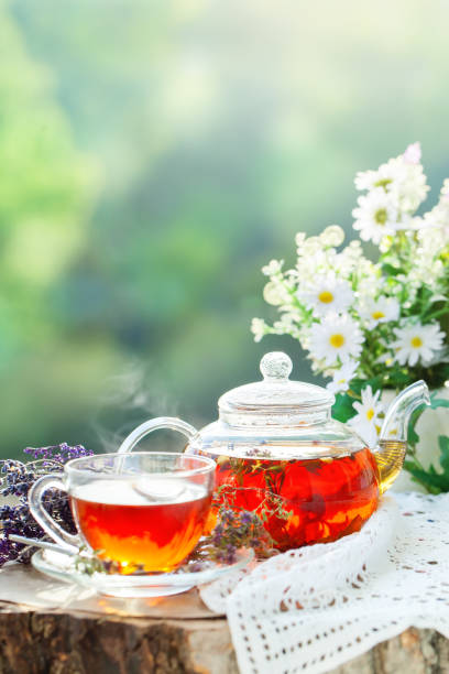 istock Cup with hot tea with mint and a thyme on a wooden table in a summer garden. Selective focus 968855582