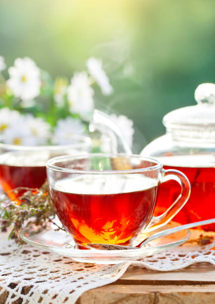 istock Cup with hot tea with mint and a thyme on a wooden table in a summer garden. Selective focus 968855732