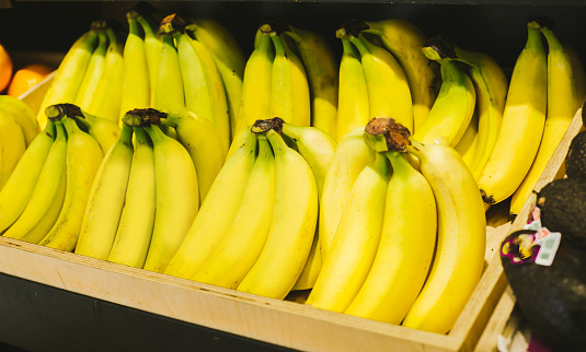 Close up photo of Fresh bananas on shelves in supermarket