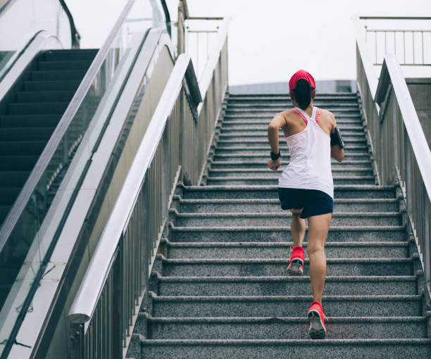 istock Young female athlete running up stairs 968860362