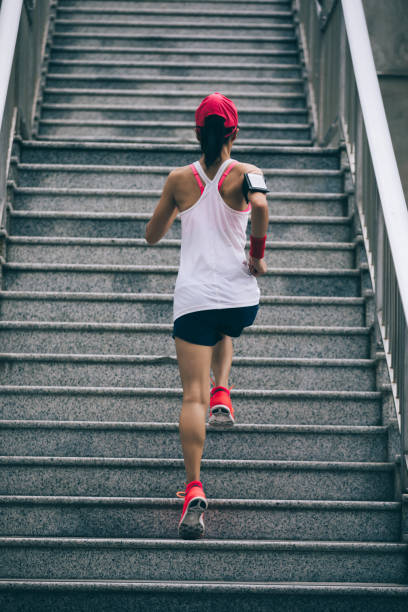 istock Young female athlete running up stairs 968860544