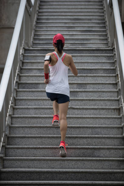istock Young female athlete running up stairs 968862702