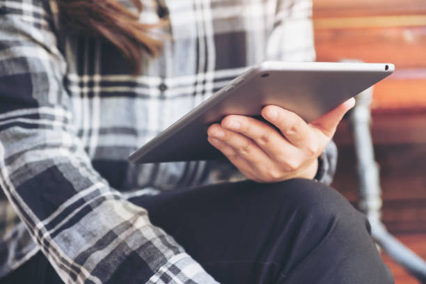 istock Closeup image of a woman holding and using tablet pc 968862890