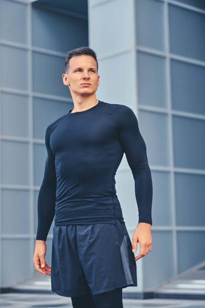 istock A man in a black sportswear over modern building background. 968868168
