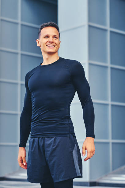istock A man in a black sportswear over modern building background. 968868616
