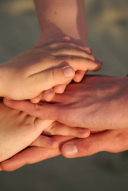 istock Kid's hands forming a pile, beach, sunset, teamwork concept 96886986