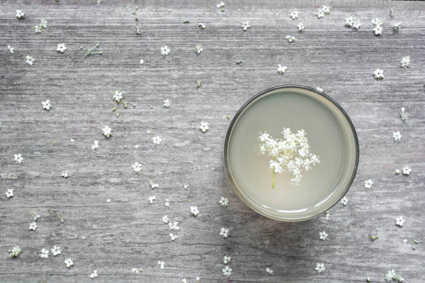 hausgemachter holunderblüten sirup mit blumen auf weißer holztisch. gesunden pflanzliches getränk. - holunderlikör stock-fotos und bilder